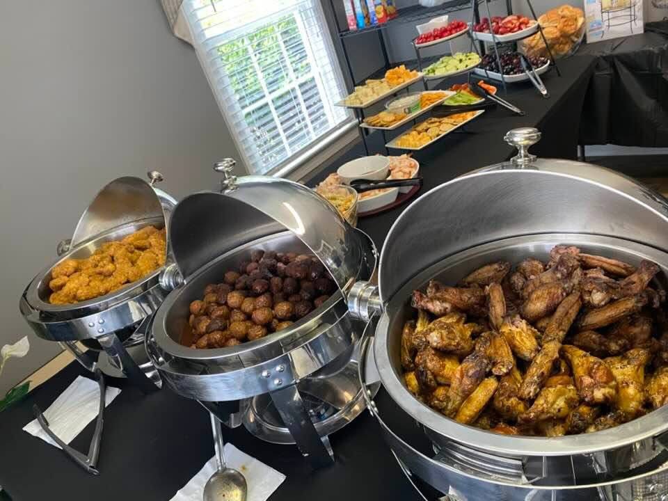 A catered buffet with wings and appetizers